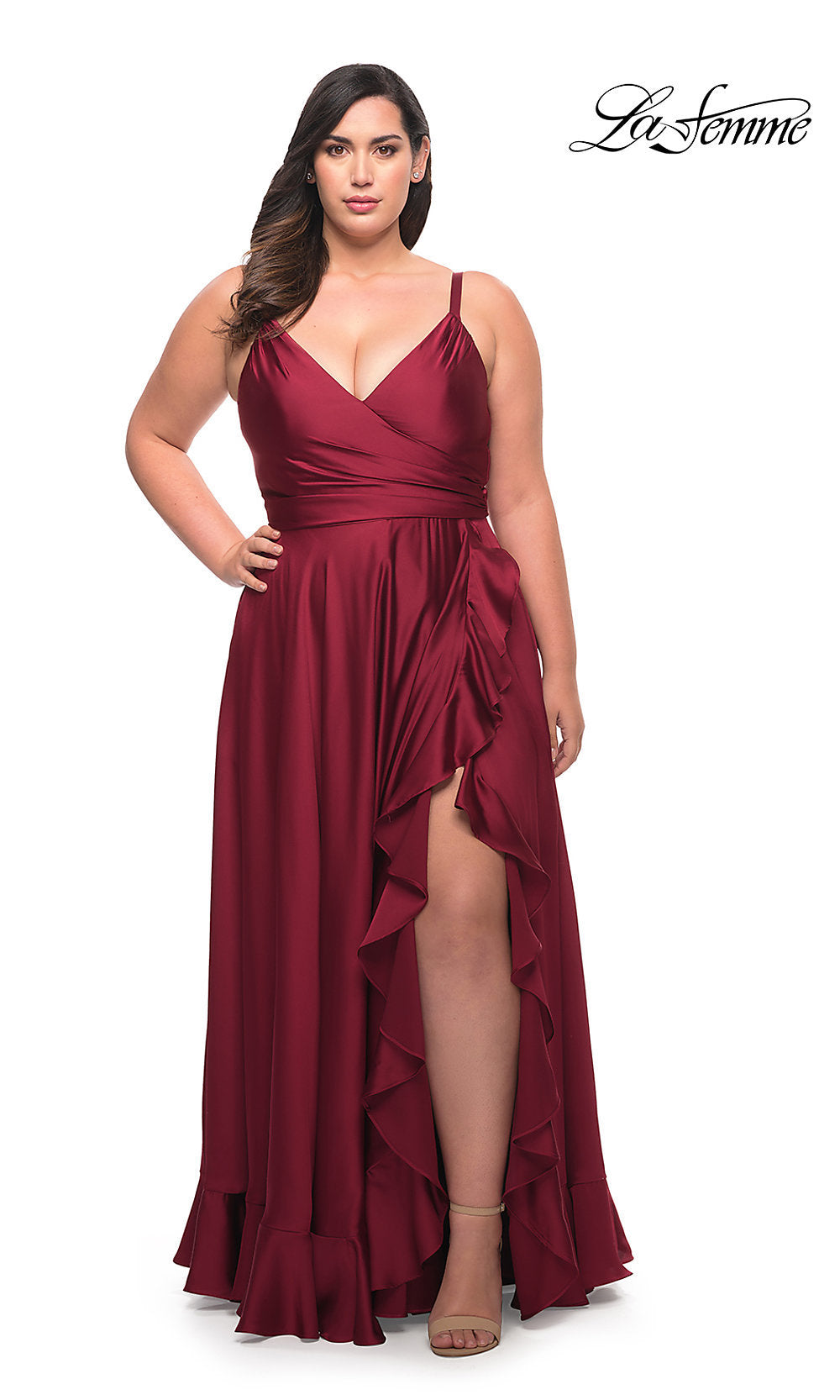 A woman models a Long Plus-Size La Femme Prom Dress in wine with a sleeveless V-neckline and ruffle hem, standing against a white background.